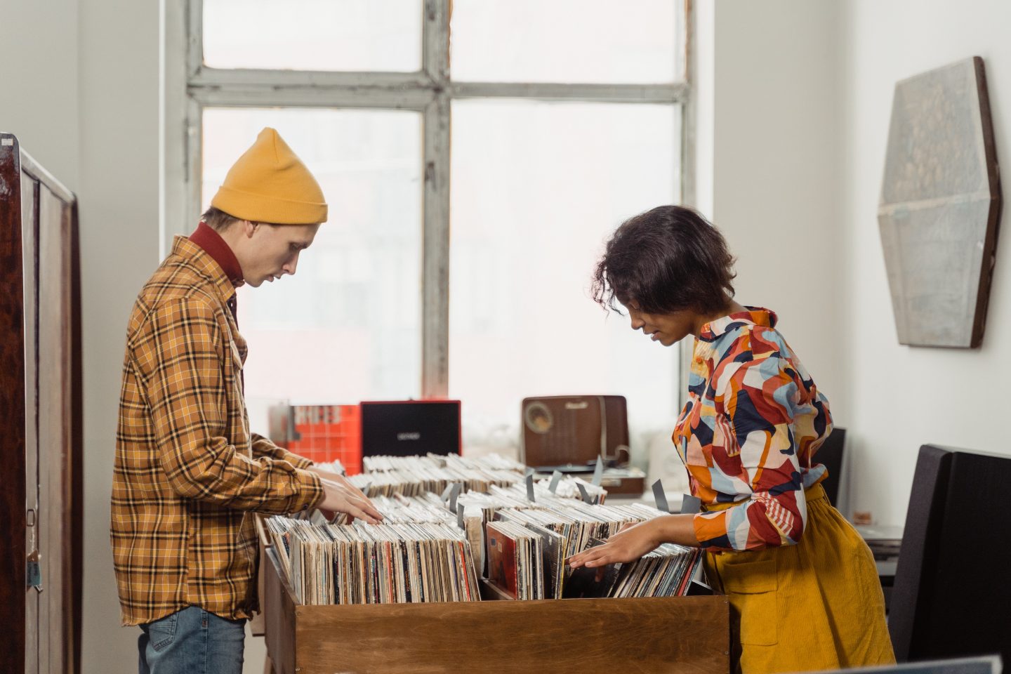 https://www.pexels.com/photo/a-man-and-woman-browsing-through-vinyl-music-records-6827191/